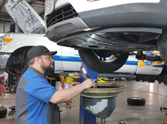 Joe S. Works on a Vehicle in Tom’s Auto Center