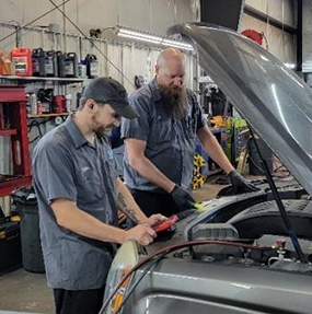 Tom's Auto Center - Taylor Taylor J. Checks Vehicle Battery - Tom’s Auto Center